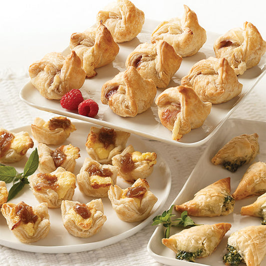 Appetizer Favorites Trio, featuring Caramelized Onion & Feta Pastry Blossoms, Brie & Raspberry en Croûte, and Spanakopita.